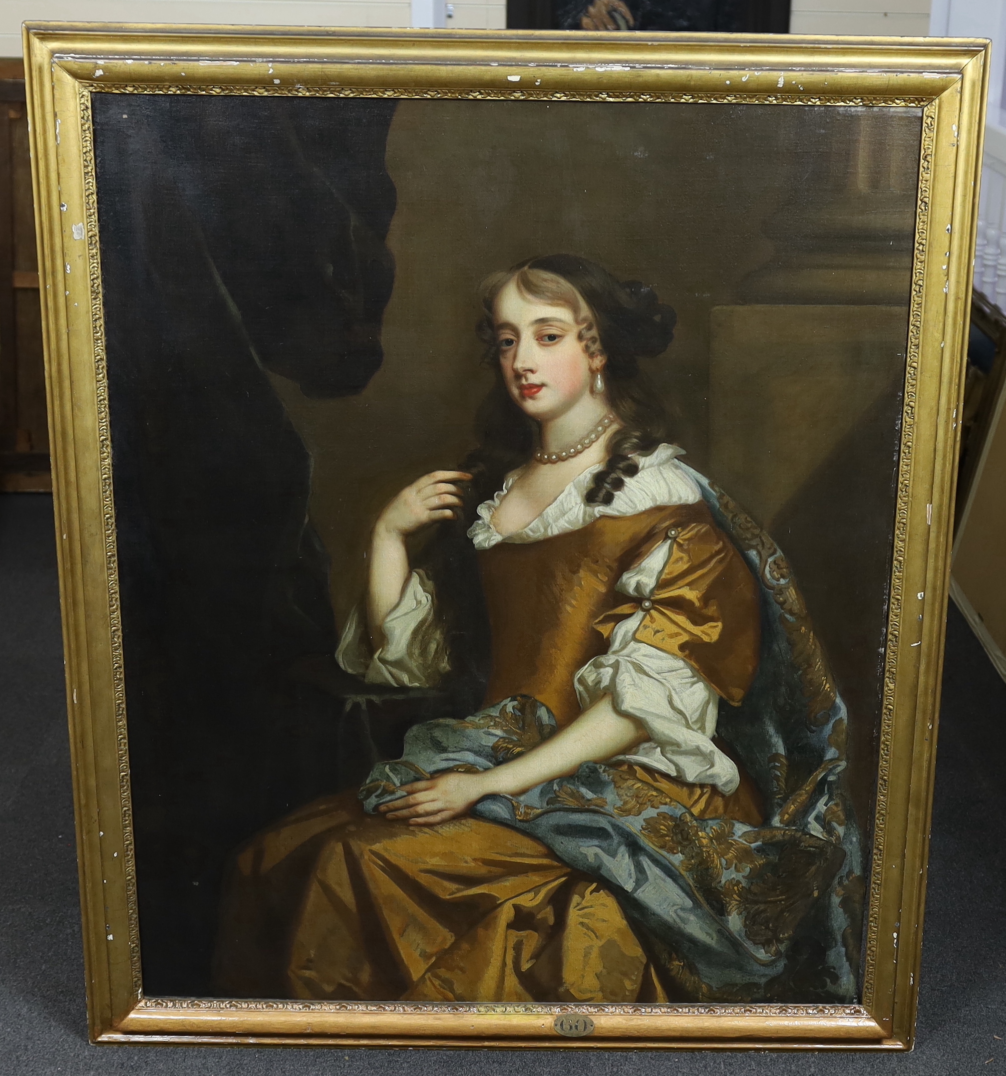 Studio of Sir Peter Lely (1618-1680), Portrait of Henrietta Hyde (née Boyle), Countess of Rochester, (1646-1687) three quarter length, in a gold dress, wearing a gold-embroidered blue mantle, seated by a pilaster, oil on